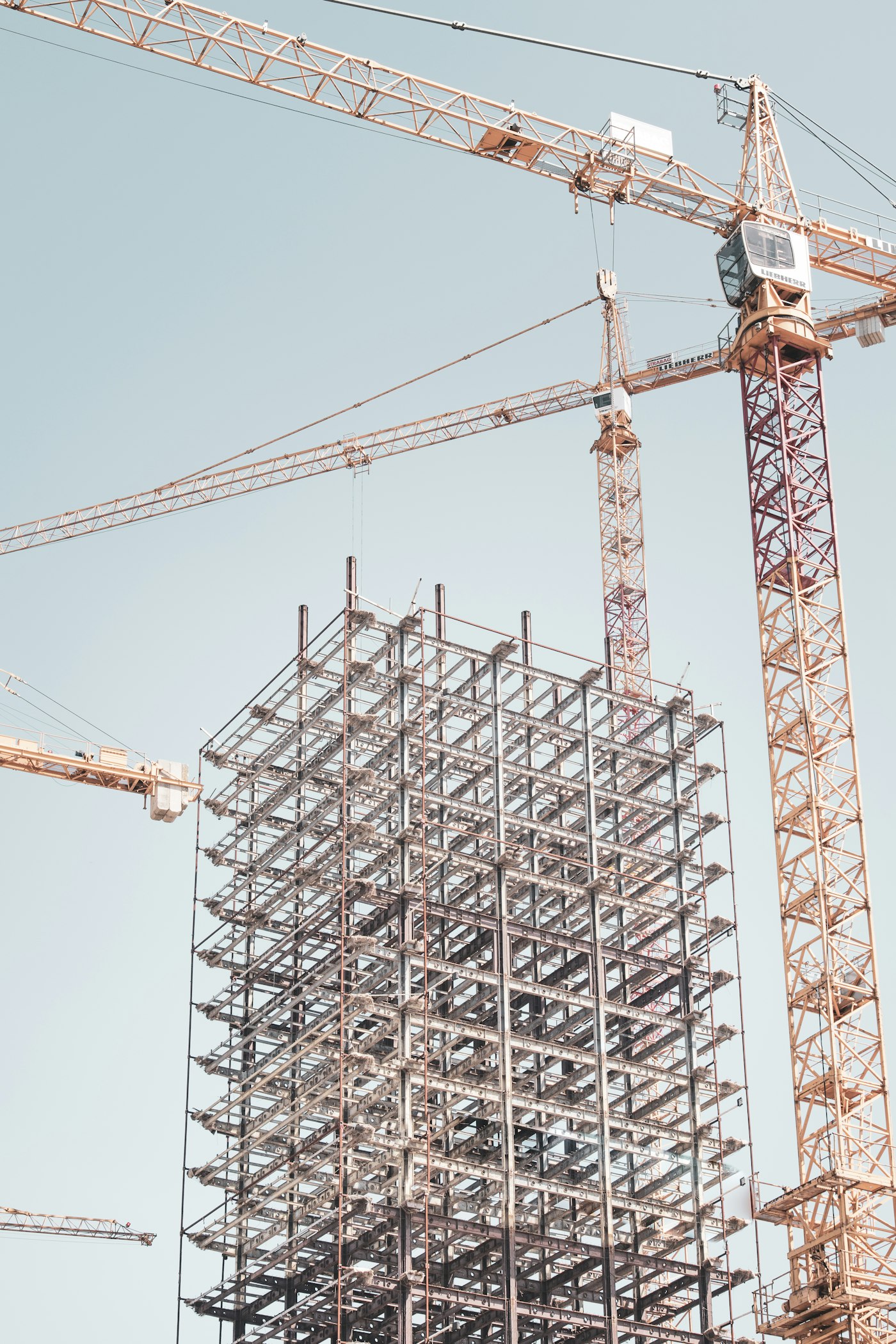 A building under construction with tower cranes
